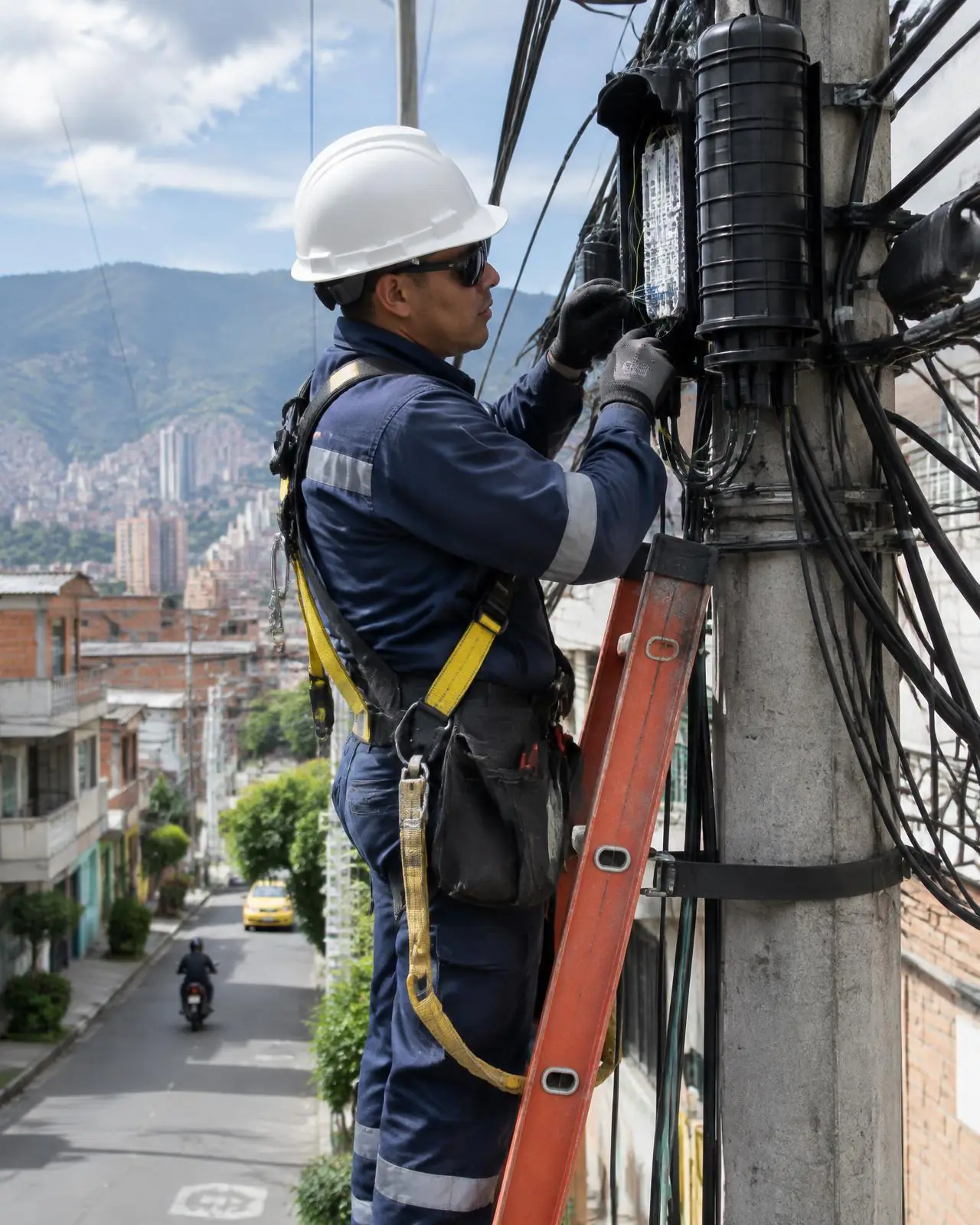 Técnico en altura interviniendo un cierre de fibra óptica aéreo en poste