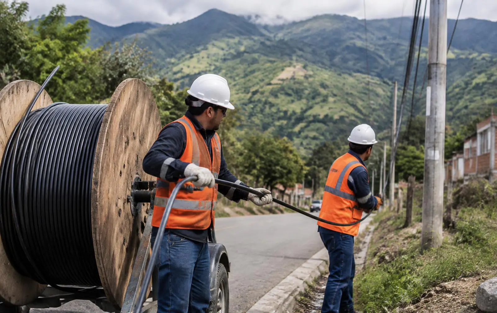 Técnicos guiando cable de fibra óptica desde un carrete en una ruta regional