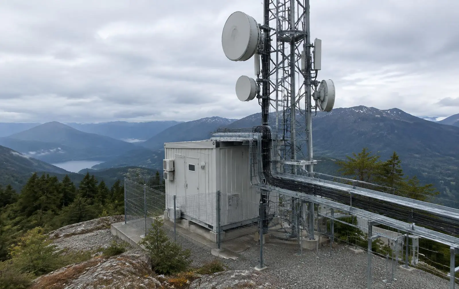 Nodo de telecomunicaciones con torre, antenas y shelter de equipos